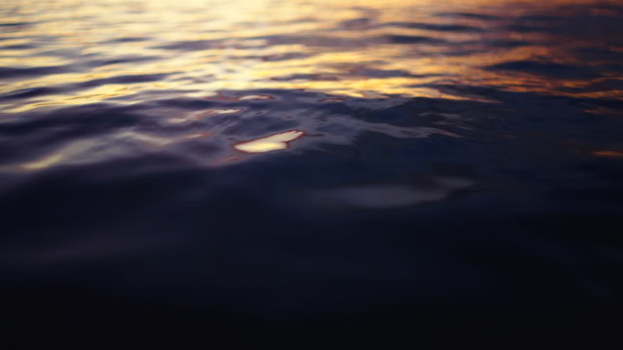 Golden Light Reflecting on Dark Water Ripples at Sunset