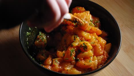 mixing chicken breast in a bowl, seasoned with spices and chopped parsley