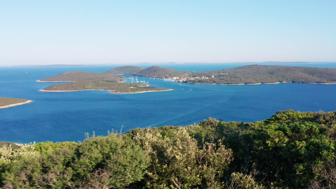 낮 동안 다른 섬에서 온 크로아티아, 로시니 섬에 있는 한 마을의 공중 롱샷