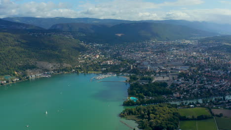 Aerial view of 'Lake Biel' and the city Biel and the Nidau-Büren Canal with clear greenish-blue water surrounded by a scenic landscape on a sunny day under blue sky with fluffy clouds CH