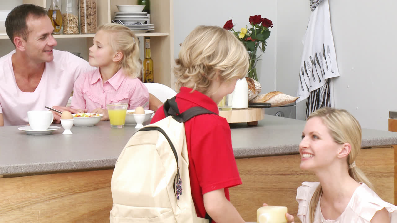 Madre che consegna a suo figlio il pranzo scolastico in cucina