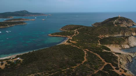 Volando-Sobre-Una-Idílica-Playa-De-Arena-Natural-En-La-Isla-De-Vacaciones-Turísticas-Cerdeña-En-Italia-Con-Sol,-Azul-Turquesa-Claro-Y-Aguas-Tranquilas-Cerca-De-Costa-Rei