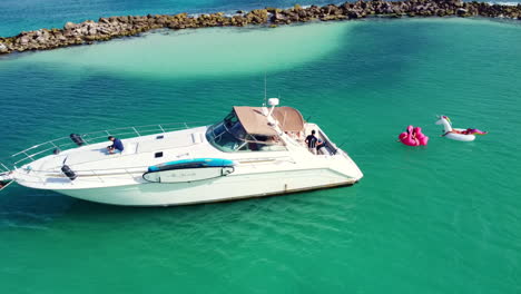 aerial view of a white yacht in puerto aventuras in the the mayan riviera, méxico while people relax on inflatables