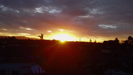 Sonne-Scheint-Durch-Wolken-Im-Morgengrauen-über-Dem-Horizont,-Drohnenaufnahmen