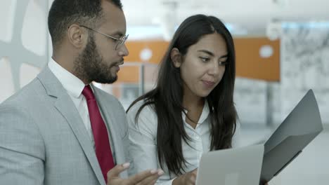 colegas de negocios con computadora portátil y carpeta