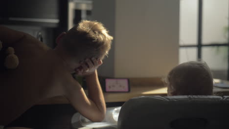 hermano con hermana bebé viendo dibujos animados en el móvil en casa