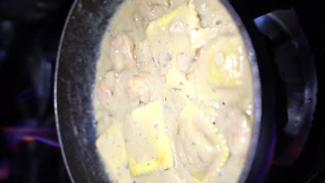 Cooking-ravioli-with-shrimp-in-sour-cream-in-cooking-pan