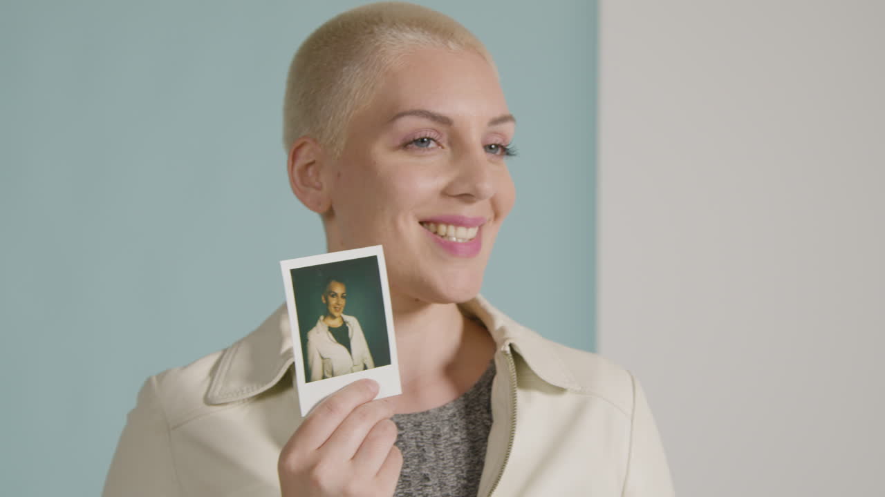 자신의 사진을 들고 있는 여성 모델 궤도를 도는 트래킹 샷