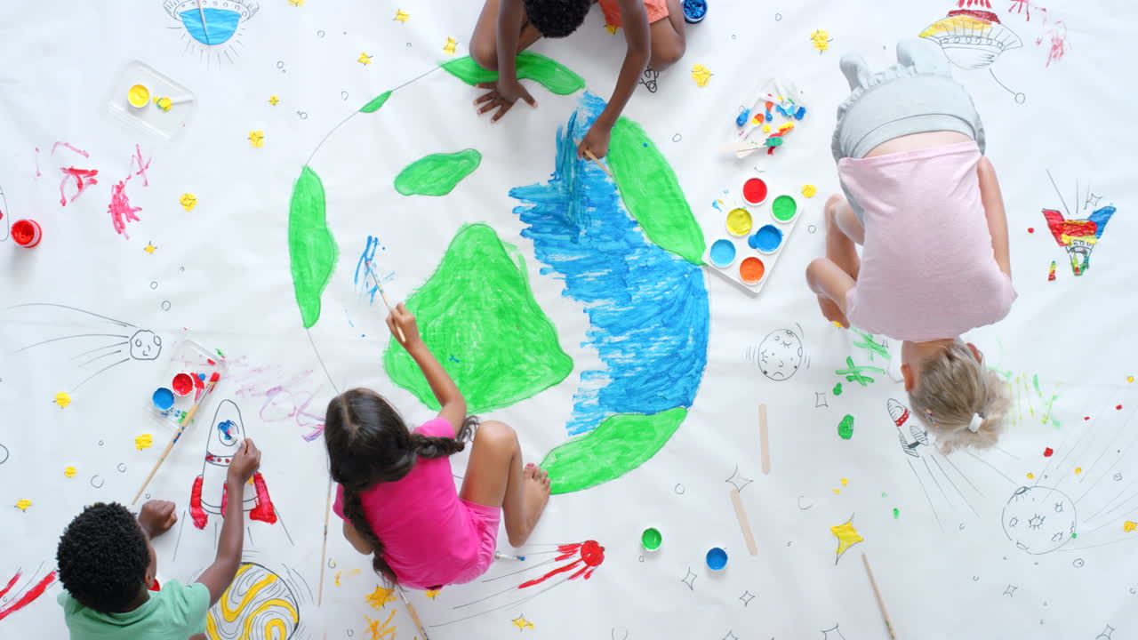 niños pintando una escena gigante de la tierra y el espacio