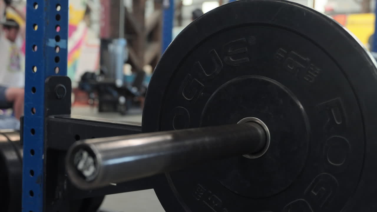 Putting weights on a barbell in a gym, close up