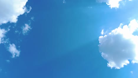 sky time lapse clouds and blue sunny sky, loop of white clouds over blue sky with sun rays, aerial view, drone shooting clouds motion time, nature blue sky a white clear weather