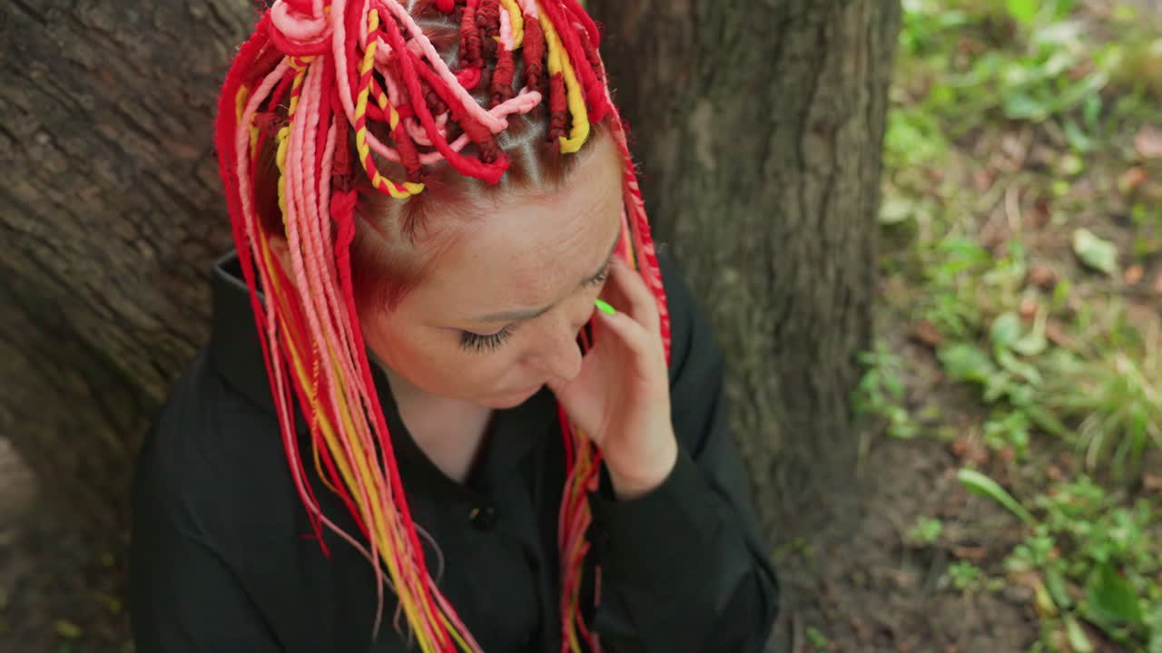 petición de ayuda en un parque tranquilo, una mujer caucásica pide ayuda en voz baja en un entorno pacífico, una mujer ansiosa hace una delicada llamada para tranquilizarse en un entorno natural y apacible