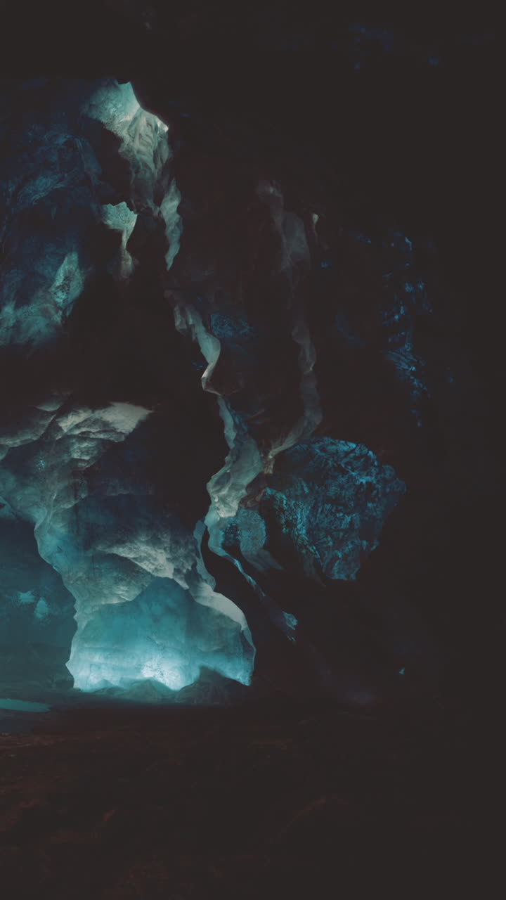 Exploring a dark cave with blue light and rocky formations in nature