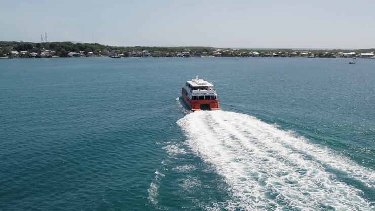 ferry en el mar caribe, llegando a la isla de utila, honduras - vista aérea
