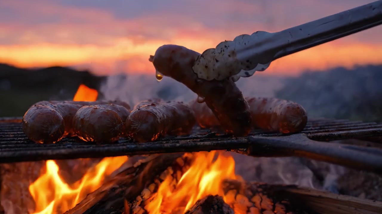 Salsicce alla griglia su fuoco aperto al tramonto, che catturano un'esperienza culinaria sfrigolante tra un tramonto vibrante e fiamme tremolanti.