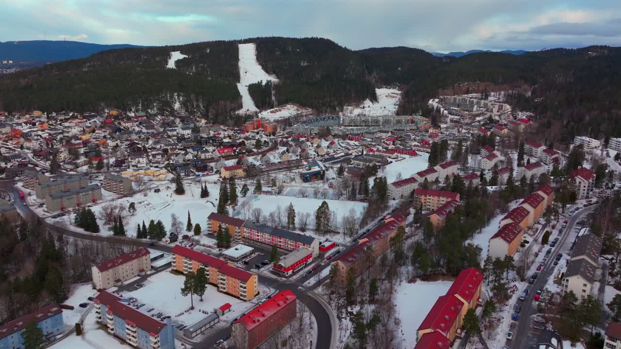 Bjerke Arvoll Tonsengagen Oslo Norge Norway Skikurs skisenter aerial drone cold cloudy winter day gray skies city neighborhood buildings landscape Arctic circle snowing backwards motion