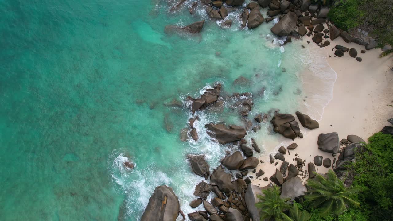 Rekaman drone mata burung pantai tersembunyi dekat pantai North East Point, bebatuan besar, pantai berpasir putih, dan air pirus, Mahe Seychelles 30fps 2