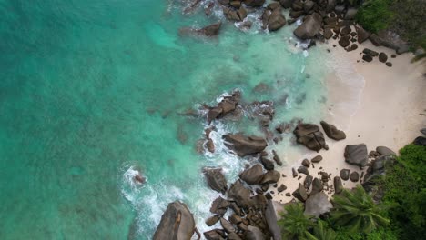 Bird-eye-drone-shot-of-hidden-beach-near-north-east-point-beach,-huge-rock-boulders,-white-sandy-beach-and-turquoise-water,-Mahe-seychelles-30fps-2