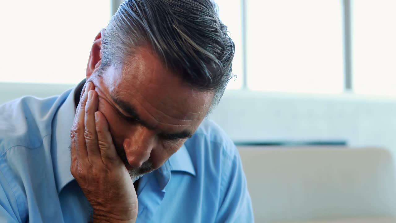 ejecutivo masculino tenso sentado en el sofá 4k