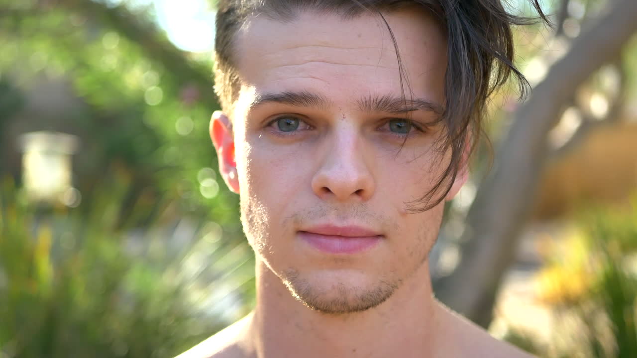 마음챙김, 현재의 인식, 긍정성에 초점을 맞춘 반성 명상 세션 동안 정원에서 행복하게 웃고 있는 젊고 잘생긴 백인 남성