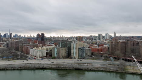 Drone-shot-over-the-river-and-the-cityscape-of-cloudy-Harlem,-New-York,-USA