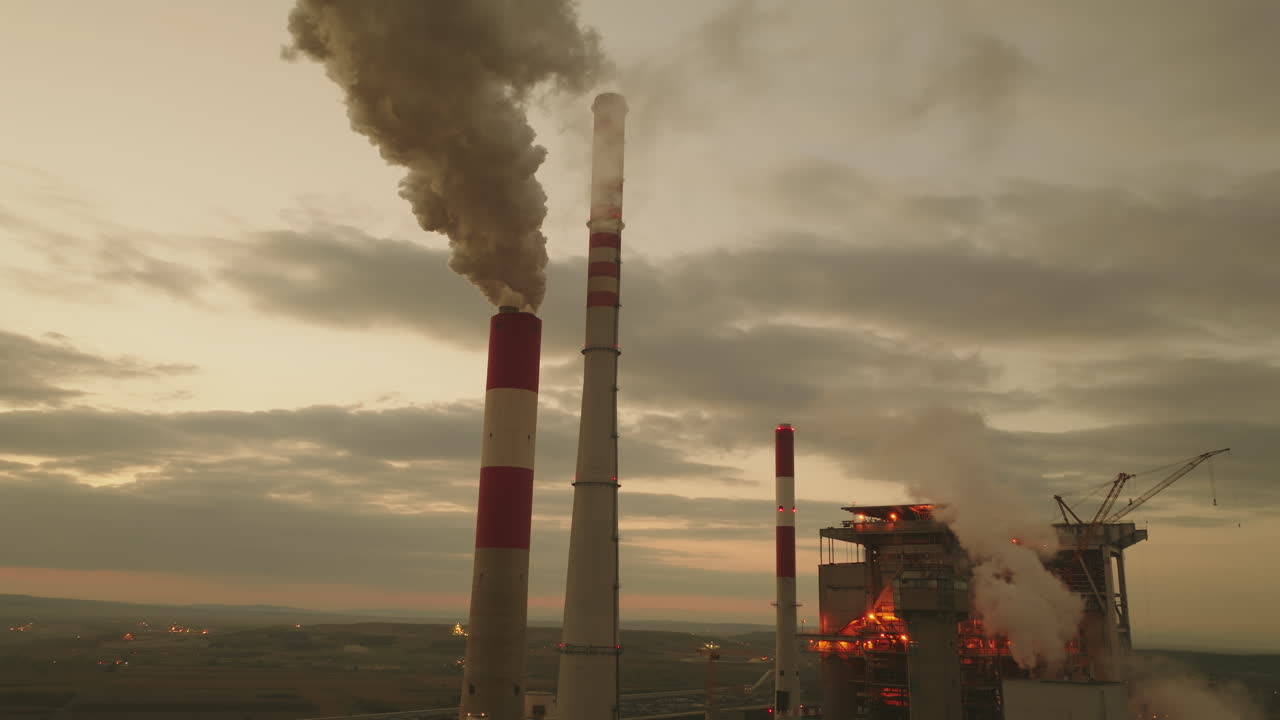 centrale elettrica al tramonto con emissioni di fumo