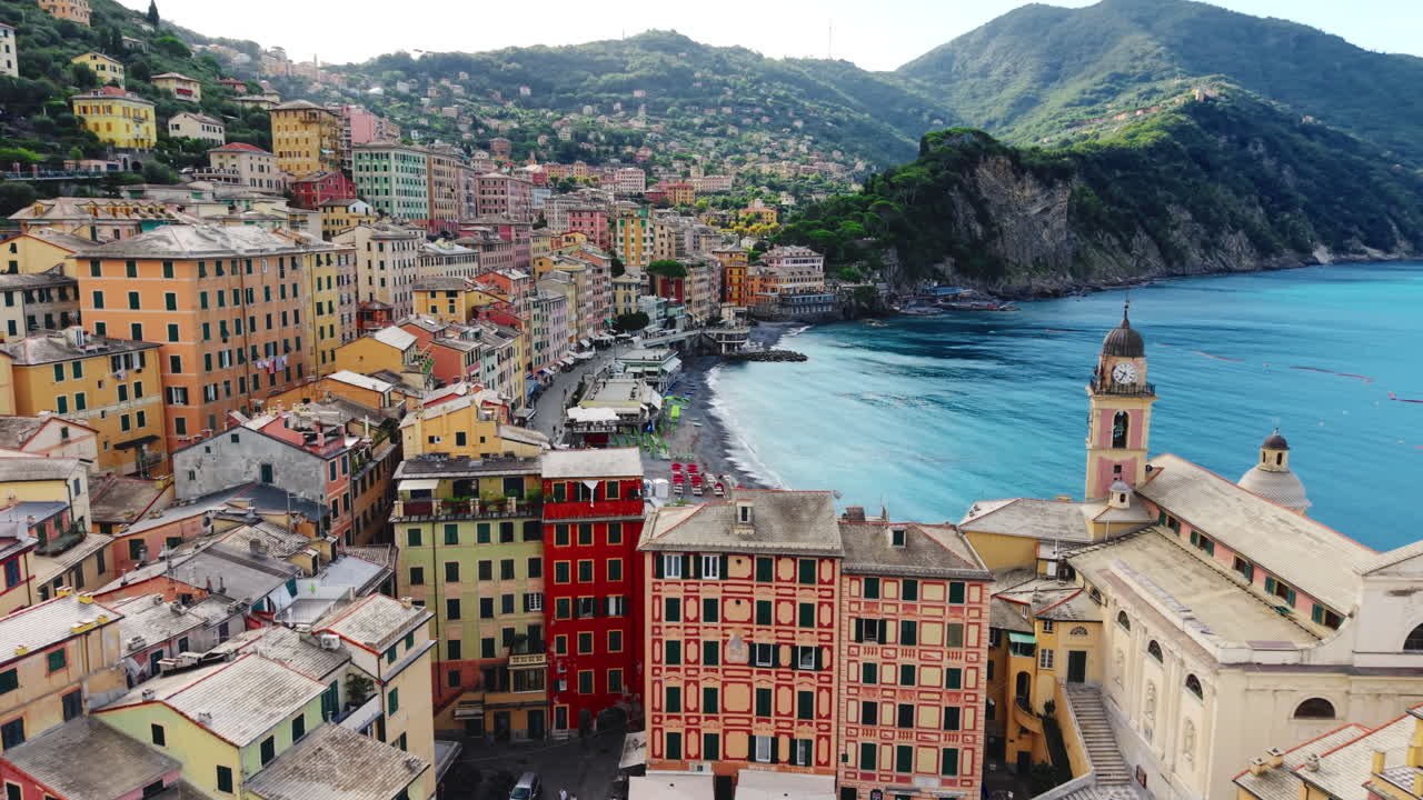 Drone avanza sul porto di Camogli verso la spiaggia con edifici colorati