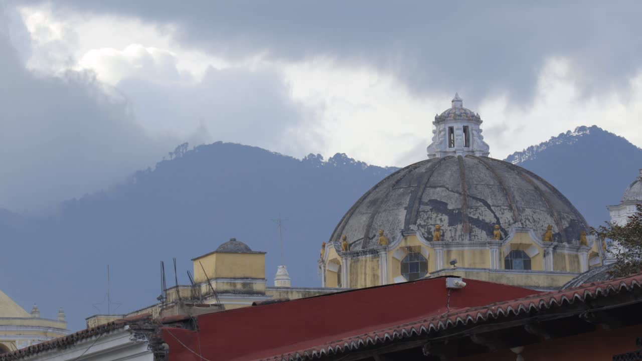 Static establishing of Antigua City with colonial rooftops and surrounding volcanic landscape, Guatemala, telephoto
