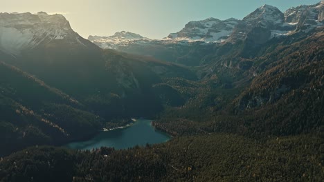 Weite-Drohnenschwenkansicht-Auf-Dolomiten,-Felsige-Berge-In-Den-Italienischen-Alpen,-Mit-Kleinem-See-Und-Kiefernwald-In-Der-Wintersaison