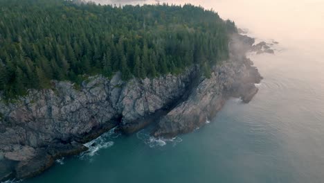 orbiting drone captures dawn over maine’s bold coast with fog on the water