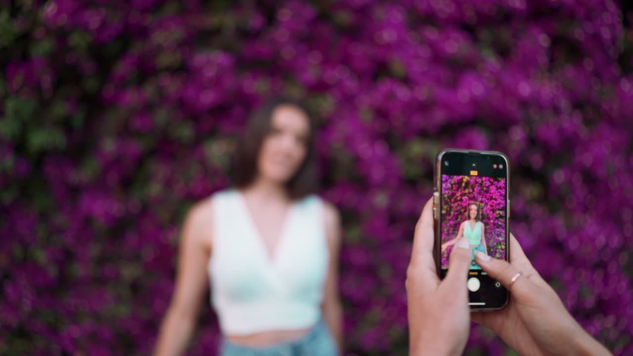 Kvinne som fotograferer foran bougainvillea-blomster