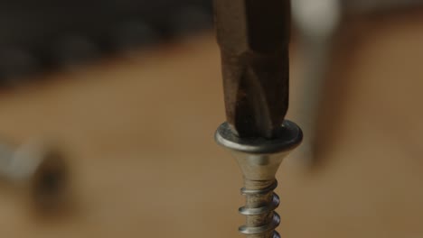 macro view of electric screwdriver drilling out metal screw in slow motion