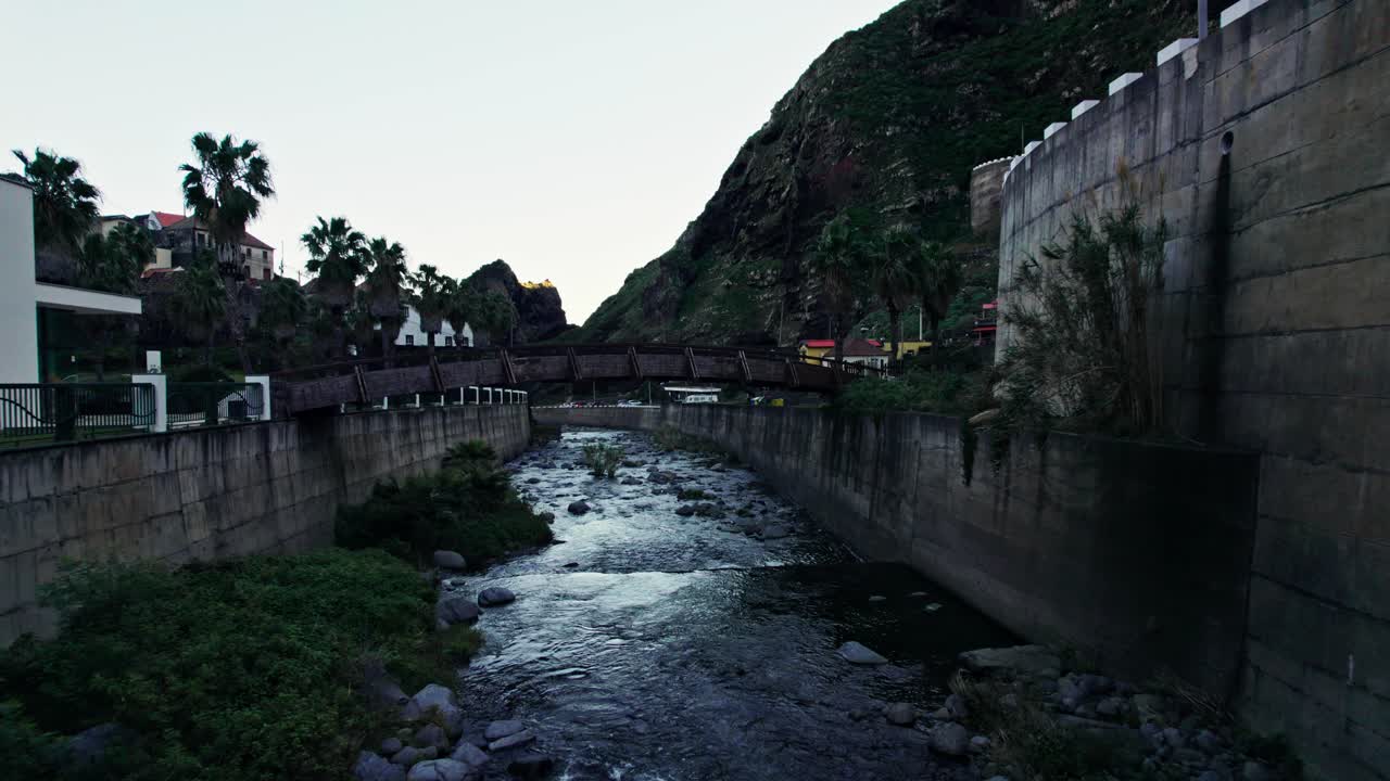 Wooden Bridge Over a Canal in a Mountain Town