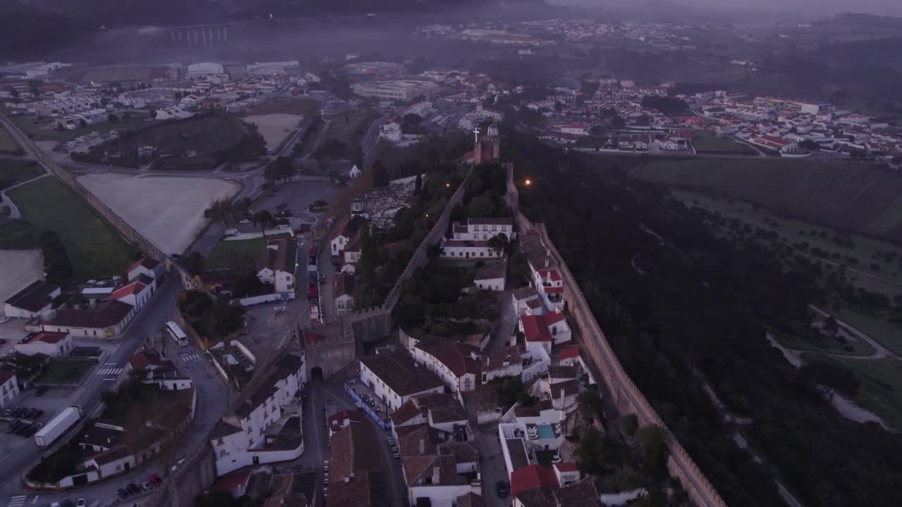 fotografía de la famosa ciudad de obidos, portugal, con nubes bajas al amanecer, inclinación aérea