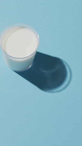 video de un vaso de leche fresca sobre un fondo azul