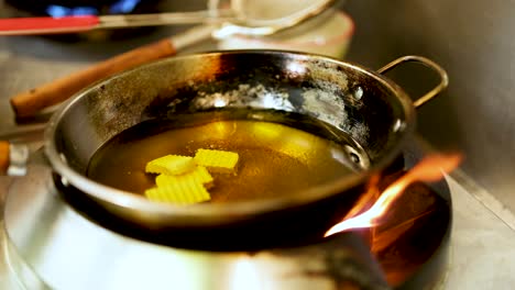 potatoes frying in hot oil in a pan