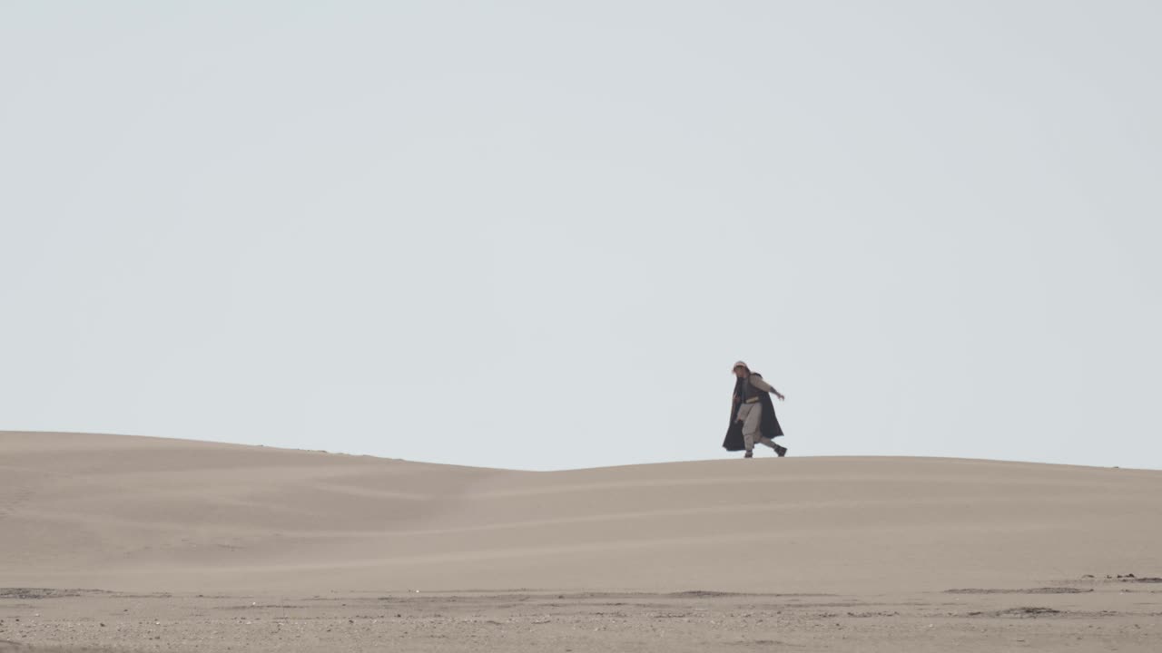 A robed figure struggles across a vast sand dune, then falls to their knees in exhaustion. Post-apocalyptic, sci-fi, or fantasy concept of despair, struggle, and survival