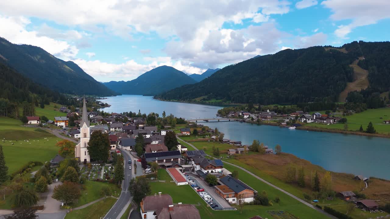 Scatto frontale di una piccola chiesa con splendida vista sulla campagna e sulle montagne, Austria