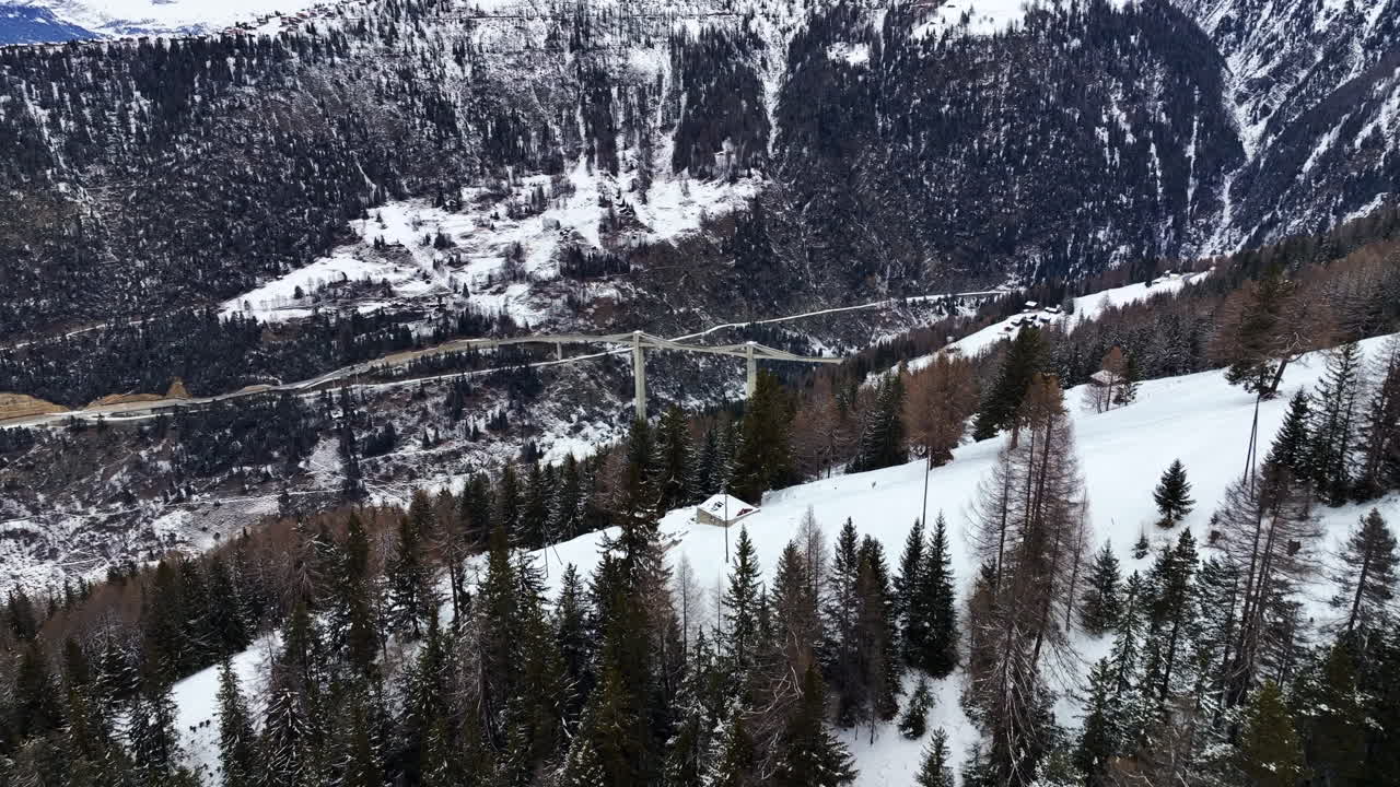 amplia toma de drones del ultra moderno puente ganter entre los altos alpes suizos cubiertos de nieve blanca