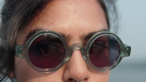 close-up of a woman with glasses looking into the camera