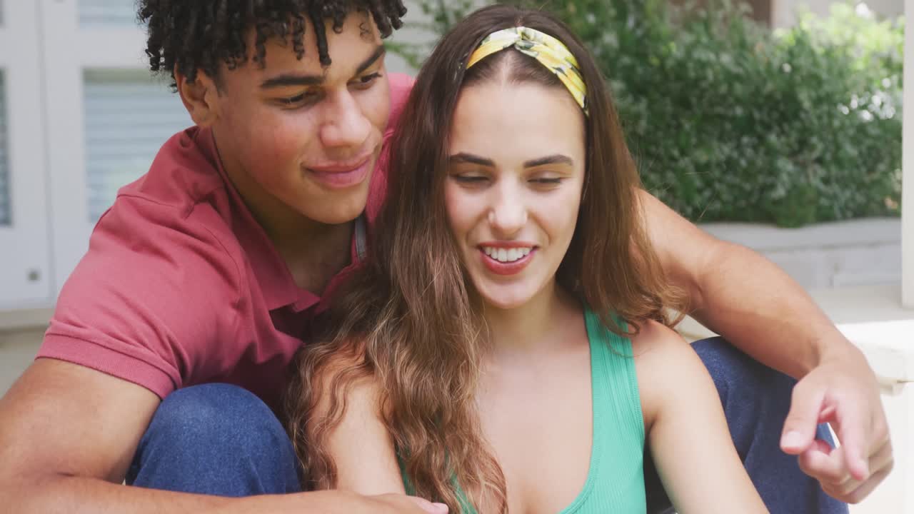 feliz pareja biracial pasando tiempo en casa y tomando selfies