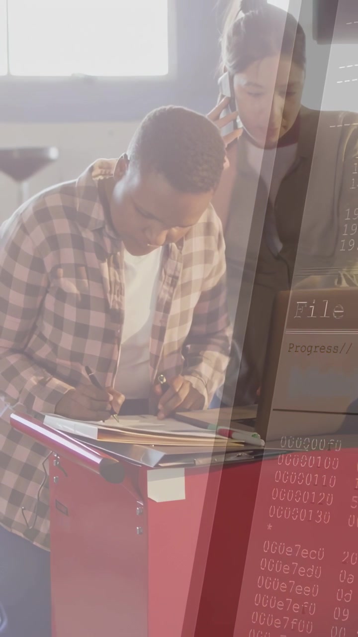 Vertical video: Plaid-shirt woman leaning over red chest, writing forms for shop, laptop UI showing