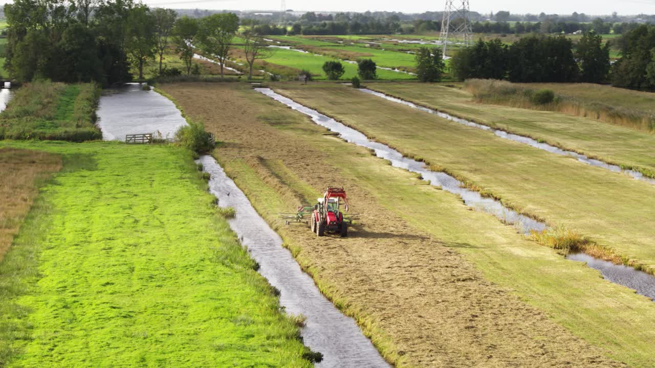 tierras de cultivo en los países bajos con tractor para la recolección de heno