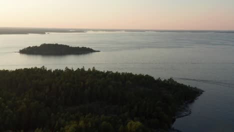 Drohnenaufnahme-Des-Stockholmer-Archipels-In-Schweden-Bei-Sonnenuntergang-Mit-Dem-Boot