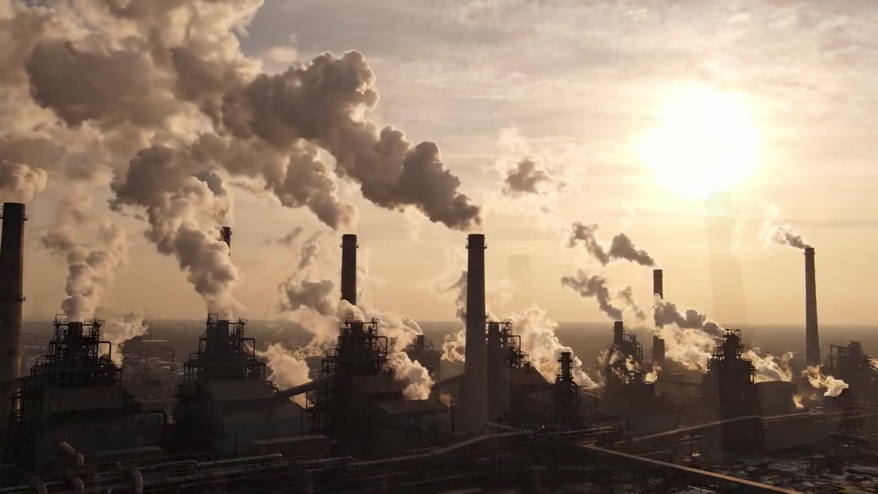 Industrial Landscape: A Dramatic View of Smoke Emitting from Heavy Machinery at Dusk, Highlighting the Impact of Manufacturing on the Environment