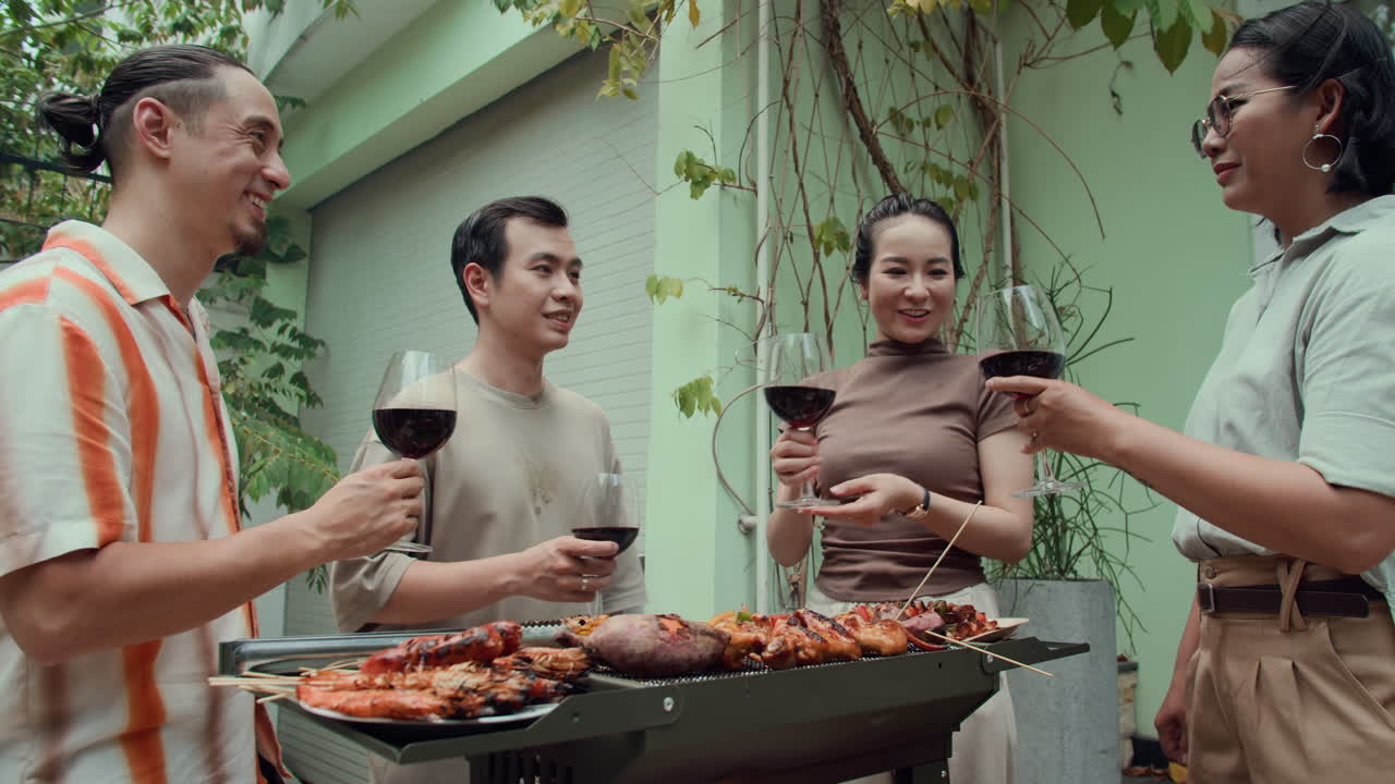 Group of Friends Having Grill Party with Red Wine Outdoors