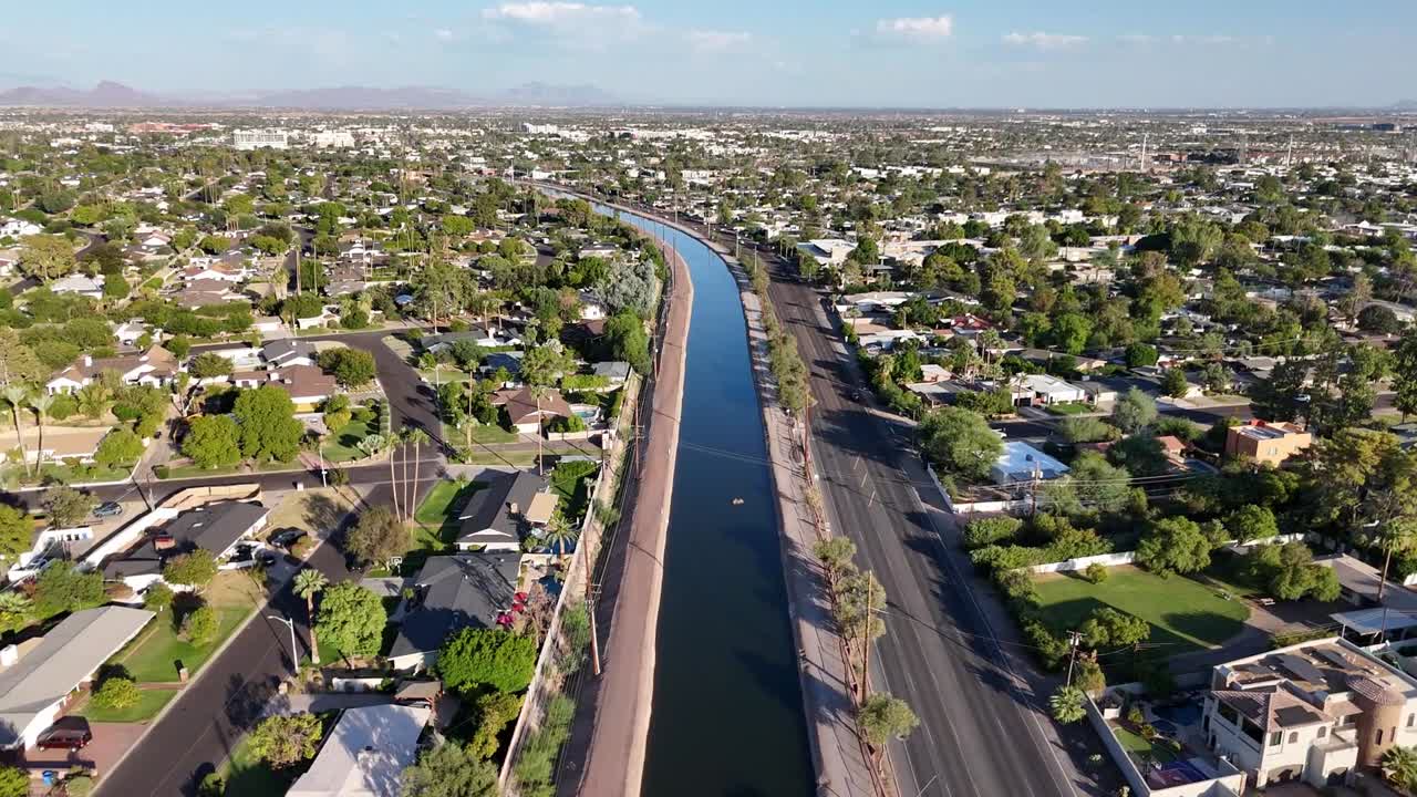 Aerial view of water canal in Phoenix, Arizona. with houses, streets and palm trees on the side