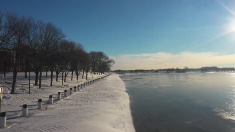 frozen winter landscape drone footage with sun reflecting off water