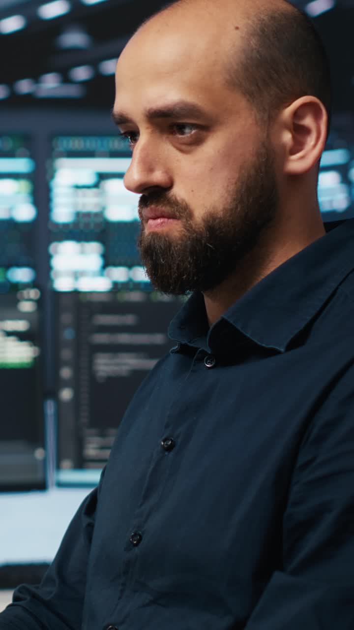 Focused Man Working on Computer in Dark Server Room