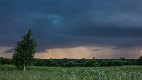 Zeitrafferaufnahme-Dunkler-Wolken,-Die-Am-Himmel-über-Einer-Grünen-Wiese-Fliegen-–-Die-Sonne-Versteckt-Sich-Hinter-Wolkenlandschaften